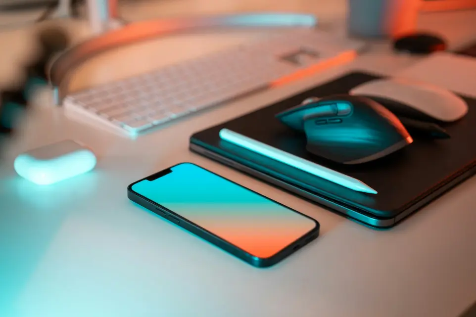 a laptop, mouse, and cell phone on a desk